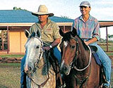 Stones riding horses in front of country owner built kit home